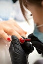 Painting nails of a woman. Hands of Manicurist in black gloves applying red nail polish on female Nails in a beauty Royalty Free Stock Photo
