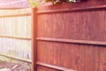 Painting old wooden fence with a brown paint