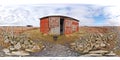 A painting of an outhouse standing in a vast field under a blue sky