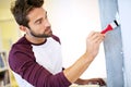 Painting, paintbrush and man in home for renovation, remodeling and maintenance for white wall. Interior design Royalty Free Stock Photo