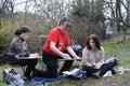 Painting in a park. Male painter giving lessons of drawing for two girls