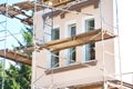 Painting and Plastering Exterior House Scaffolding Wall. Home Facade Insulation, Sctucco and Painting Works During Exterior Wall Royalty Free Stock Photo