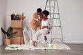 Painting, pregnancy or home with a black couple in DIY, renovation or house remodel with a paintbrush or roller Royalty Free Stock Photo
