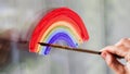 Painting rainbow on window. LGBT pride rainbow include of Lesbian, gay, bisexual, and transgender.