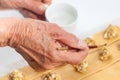 Painting ravioli dough with water to seal it