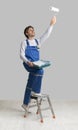 Painting Services Concept. Worker Holding Paint Roller, Applying Dye To Ceiling Royalty Free Stock Photo