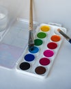 Painting set. Watercolor paints of twelve colors, brushes on a white sheet Royalty Free Stock Photo