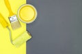 Painting tools for house renovation - paintbrush, paint roller and can of yellow paint.