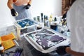 Painting tutorial. Two young women in the gloves paint with liquid acrylic in an art workshop. Acrylic Fluid Pouring. Dirty glass Royalty Free Stock Photo