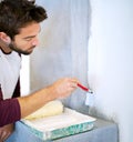 Painting, wall and man in home for renovation, remodeling and maintenance with white paint. Interior design, decoration Royalty Free Stock Photo