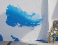 Painting the walls of the house with blue paint in the village. Image generated by artificial intelligence