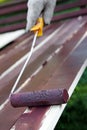 Painting wooden plank with roller