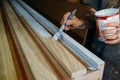 Painting wooden planks white, work in a carpentry workshop, a brush in a man's hand Royalty Free Stock Photo