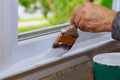 Painting a wooden with paintbrush while painting window trim Royalty Free Stock Photo