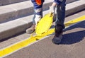 Painting of a yellow stripe parking, on the ground (France).