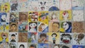 Paintings and sculpted faces of people on the wall for memoir