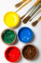 paints in jars and a brush on a white sheet of paper Royalty Free Stock Photo