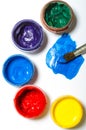 Paints in jars and a brush on a white sheet of paper Royalty Free Stock Photo