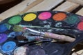 Paints and paint brushes lie on a wooden plank of boards. Royalty Free Stock Photo