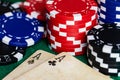 A pair of aces, Clubs and Spades, on well used vintage deck of playing cards, surrounded by Blue, Red and Black betting chips on a