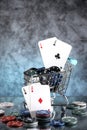 A pair of aces, hearts and diamonds, on a deck of playing cards. Poker playing chips in a blue shopping cart Royalty Free Stock Photo