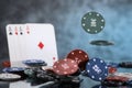 A pair of aces, hearts and diamonds, on a deck of playing cards. Poker playing chips on a dark and light blue background. Royalty Free Stock Photo