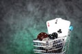 A pair of aces, hearts and diamonds, on a deck of playing cards. Poker playing chips in a blue shopping cart Royalty Free Stock Photo