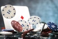 A pair of aces, hearts and diamonds, on a deck of playing cards. Poker playing chips on a dark and blue background. Royalty Free Stock Photo