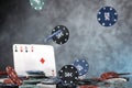 A pair of aces, hearts and diamonds, on a deck of playing cards. Poker playing chips on a dark and light blue background. Royalty Free Stock Photo