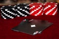 A pair of aces, hearts and Diamonds, with a unique Black faced deck of cards with Red and Black clay poker chips in a symmetrical Royalty Free Stock Photo