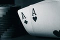 A pair of aces and poker chips, black and white photo. Ace of hearts and ace of diamonds. Nuts hand a pair of aces to Royalty Free Stock Photo