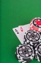 Pair of aces, red and black cassino chips on green table Royalty Free Stock Photo