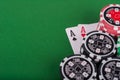 Pair of aces, red and black cassino chips on green table Royalty Free Stock Photo