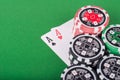 Pair of aces, red and black cassino chips on green table Royalty Free Stock Photo