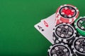 Pair of aces, red and black cassino chips on green table Royalty Free Stock Photo