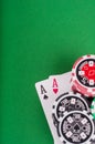 Pair of aces, red and black cassino chips on green table Royalty Free Stock Photo