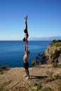 Pair acrobatics. Handstand in straight hands on the rocks by the sea