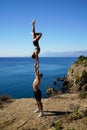 Pair acrobatics. Handstand in straight hands on the rocks by the sea