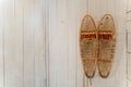 Pair of antique snow shoes on a white wooden wall background