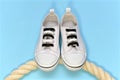 A pair of athletic shoes standing flat on a rope. Royalty Free Stock Photo