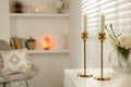 Pair of beautiful golden candlesticks on white table in room, space for text