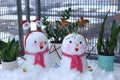 A pair of beautiful little snowmen are piled on the balcony