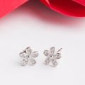 A pair of beautiful 925 sterling silver earrings in flower shape decorate with cubic zirconia Royalty Free Stock Photo