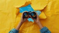 A pair of binoculars emerges through a torn yellow paper against a blue background.. AI generated Royalty Free Stock Photo