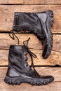 Pair of black army boots on wood.