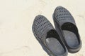 A Pair of Black Beach Shoes, Sandals or Flip Flops on White Sand Beach During A Hot Summer Day Royalty Free Stock Photo