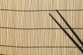 Pair of black chopsticks on bamboo mat, top view. Space for text Royalty Free Stock Photo