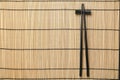 Pair of black chopsticks with rest on bamboo mat, top view. Space for text Royalty Free Stock Photo