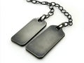 A pair of black dog tags on a chain on a white background Royalty Free Stock Photo
