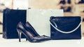 Pair of a black elegant leather women shoes with high heels, woman purse and shopping bag Royalty Free Stock Photo